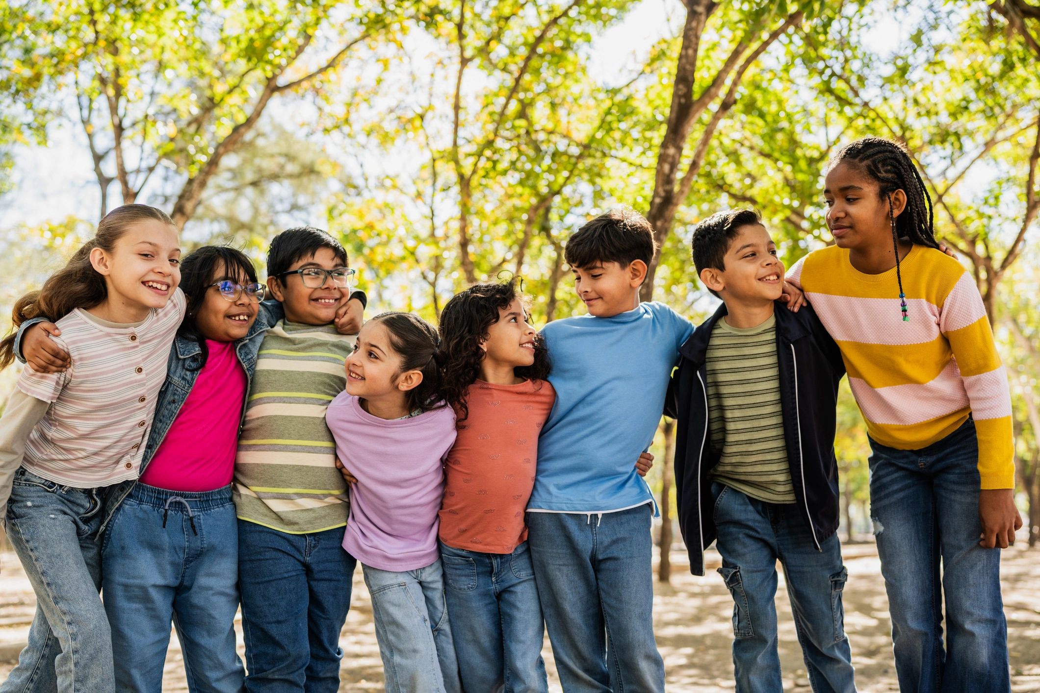 Children embracing and talking together in a park