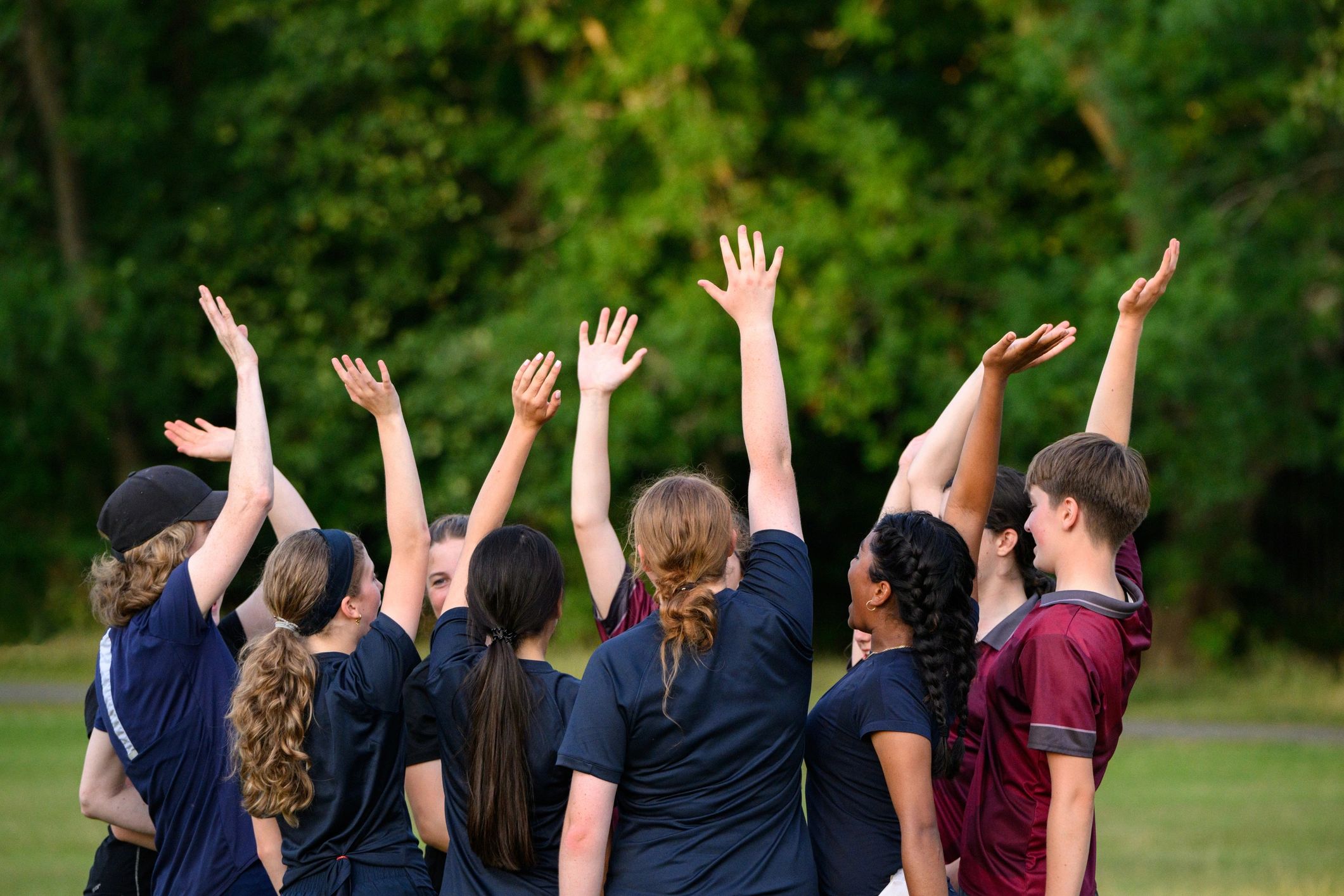 Teen athletes gathered with coach in a team huddle